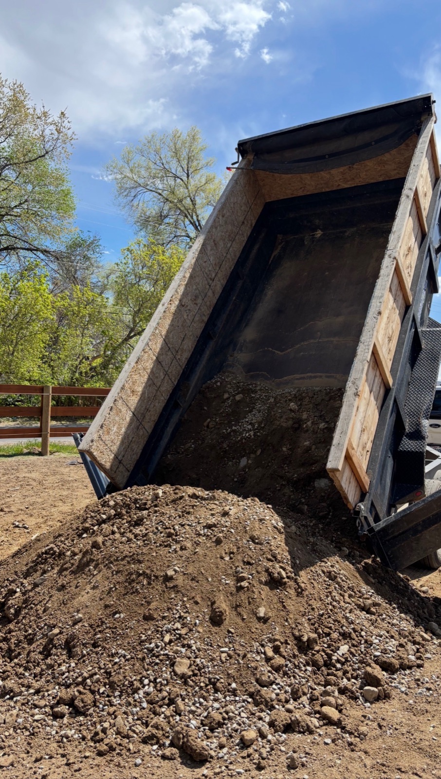 Dump truck unloading a pile of topsoil