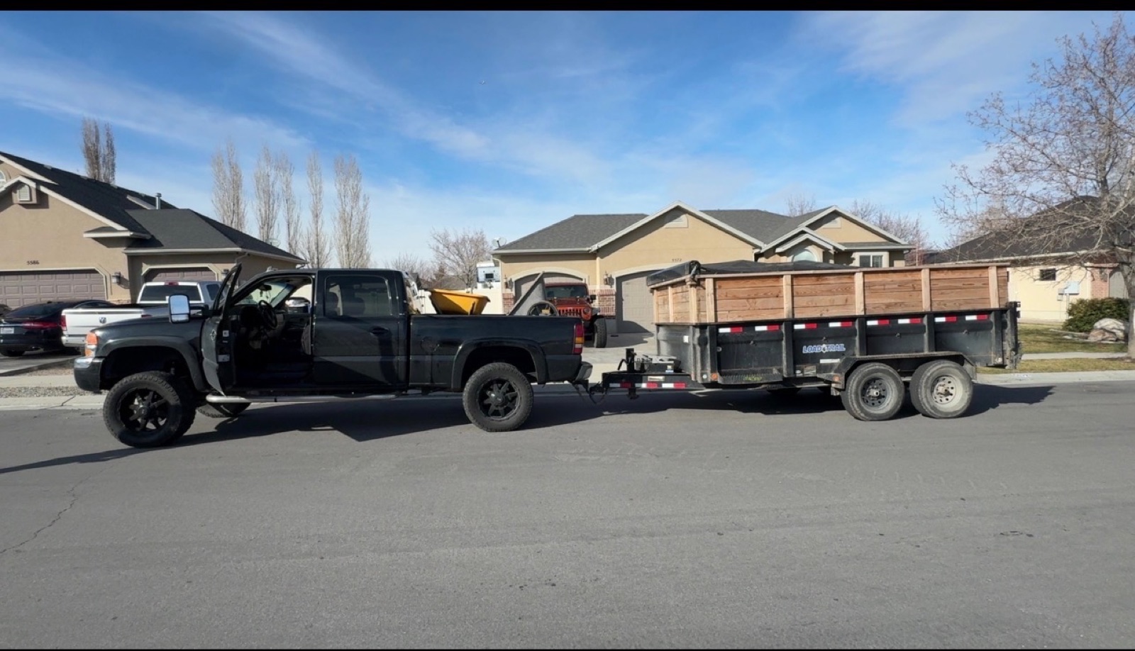 Black truck and dump trailer loaded for a haul-off job