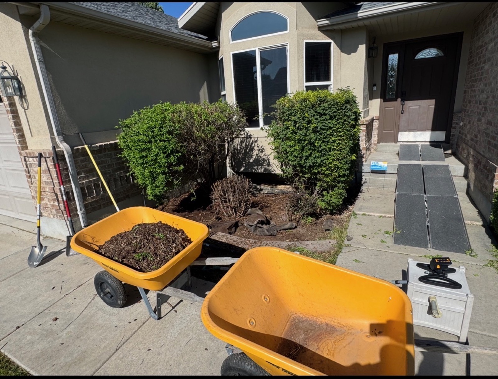 Wheelbarrow with debris in front of home during yard cleanup